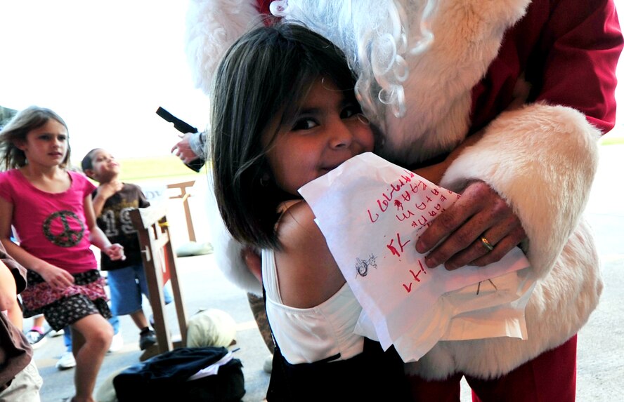 Santa Claus hugs children attending a holiday homecoming party at the 33rd Rescue Squadron maintenance hangar Dec. 10. The visit by Jolly old Saint Nick topped off a week when half of the "Jolly Green Giant" unit returned from a four-month deployment to Bagram Airfield, Afghanistan.  (Air Force/Tech. Sgt. Reynaldo Ramon)