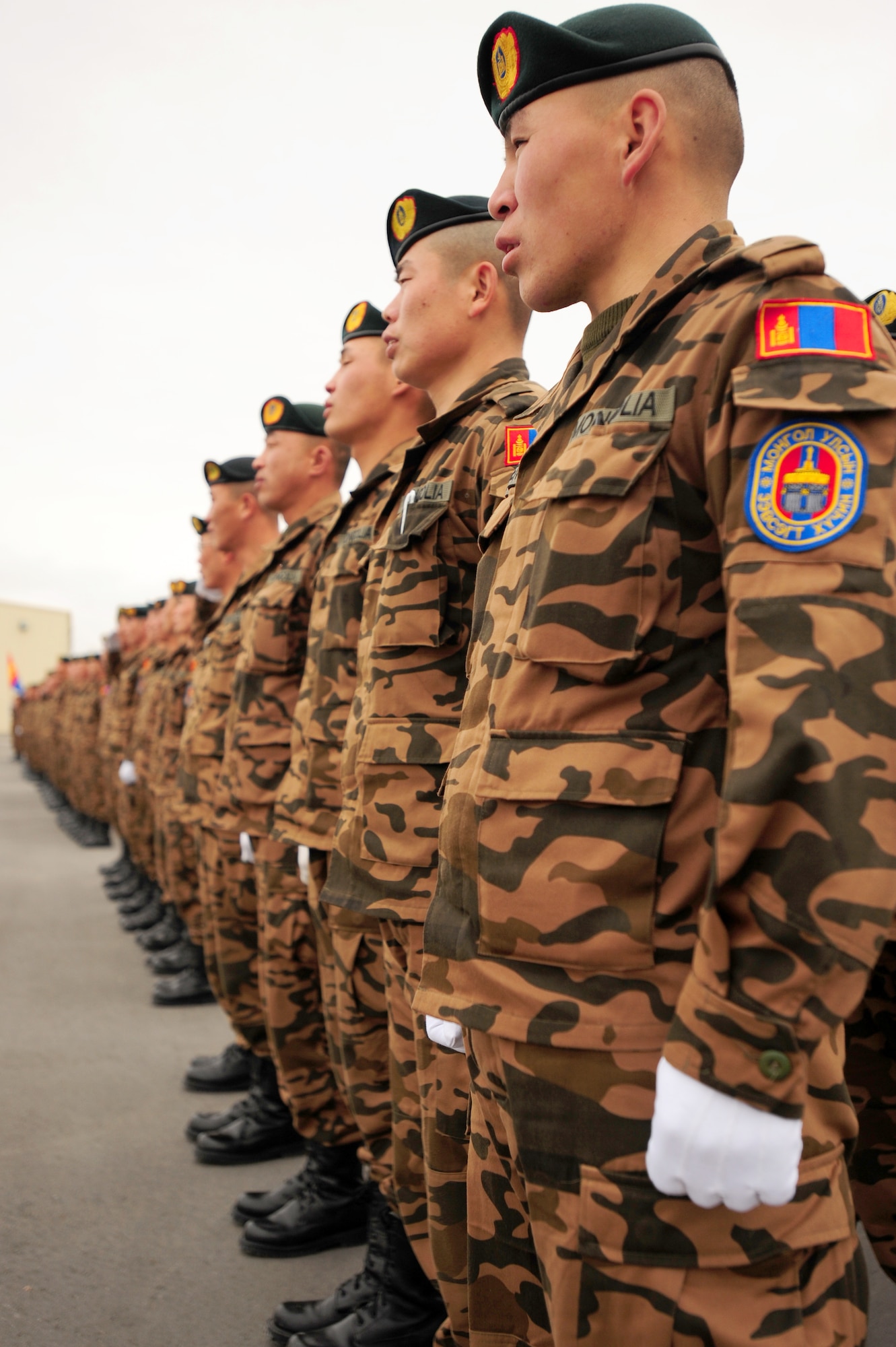 TRANSIT CENTER AT MANAS, Kyrgyzstan -- Mongolian Army soldiers stand in formation during a roll-call at the Transit Center. The Transit Center hosts all coalition partners as a part of onward movement missions at Manas in support of Operation Enduring Freedom. (U.S. Air Force photo/Senior Airman Steele C. G. Britton)
