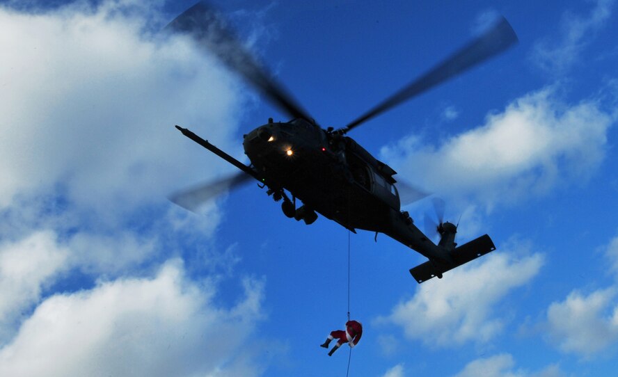 Staff Sgt. Corey Largo, a 31st Rescue Squadron pararescueman dressed as Santa Claus, rappels from a 33rd Rescue Squadron Pave Hawk before handing out presents to children attending a holiday homecoming party at the unit's maintenance hangar Dec. 10. The visit by Jolly old Saint Nick topped off a week when half of the "Jolly Green Giant" unit returned from a four-month deployment to Bagram Airfield, Afghanistan. (Air Force/Tech. Sgt. Reynaldo Ramon) 
