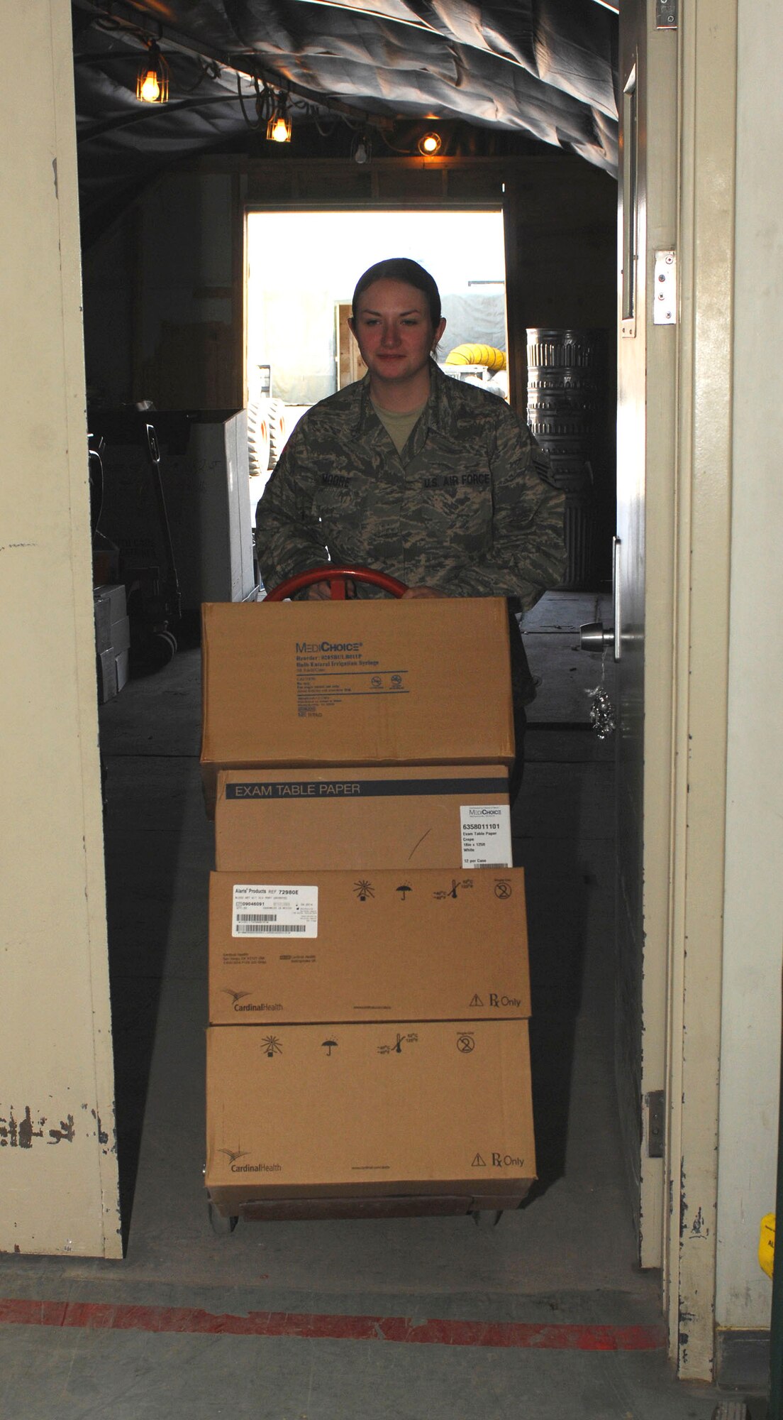 BAGRAM AIRFIELD, Afghanistan - Staff Sgt. Crystal Moore, the NCOIC of customer service, brings in supplies off a pallet. Sergeant Moore also helps out as part of the manpower team often bringing patients in from the hospital's helipad. Sergeant Moore is deployed from Fairchild Air Force Base, Wash., and a native of Fort Orchard, Wash. (U.S. Air Force photo/Tech. Sgt. John Jung)
