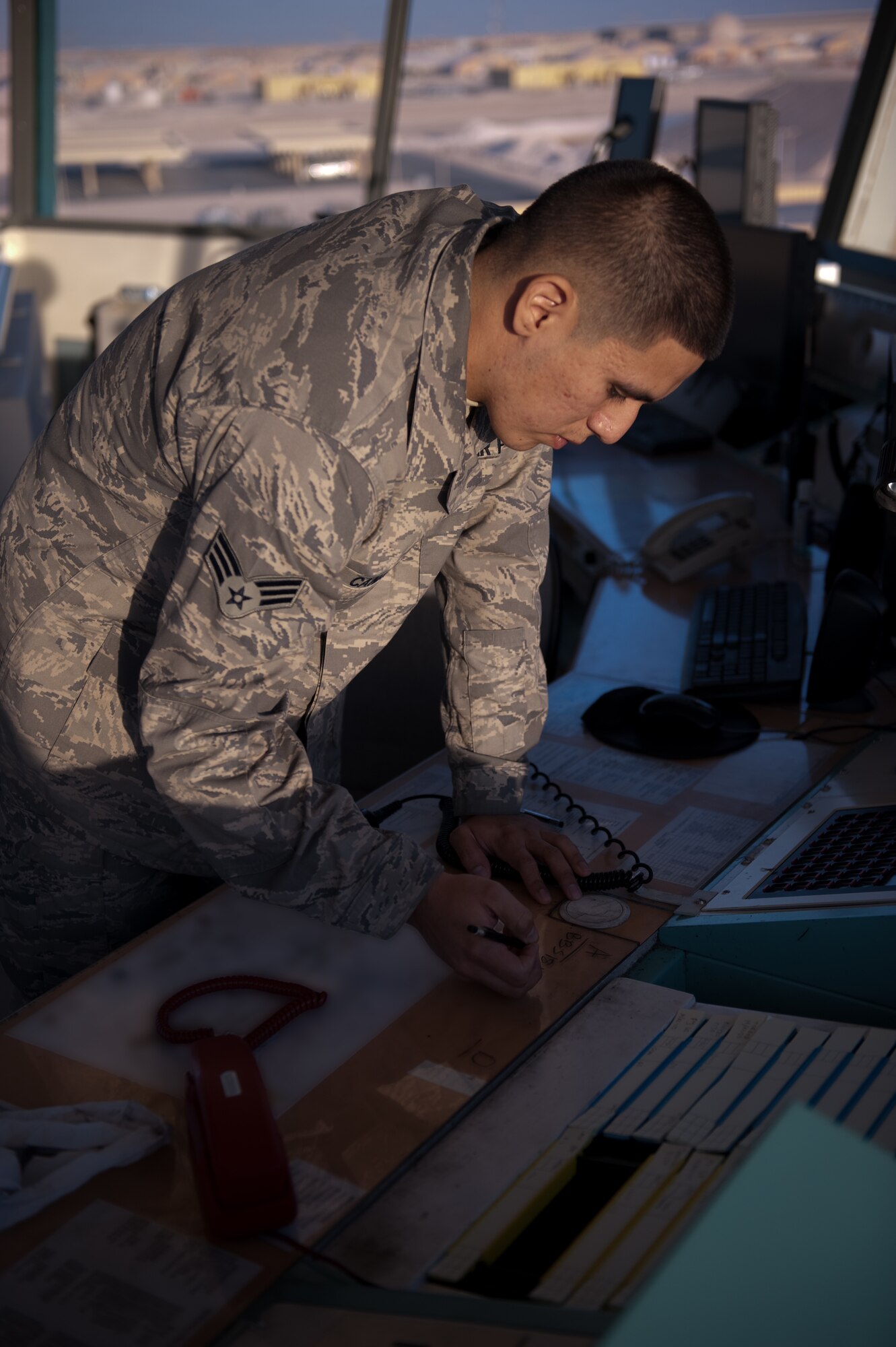 Senior Airman Salvador Canales, 379th Expeditionary Operations Support Squadron airfield traffic controller, directs aircraft passing through Southwest Asia, Dec. 9, 2009. Airman Canales is an air traffic controller responsible for expediting all aircraft taking off, landing, and transiting through the airfield here. (U.S. Air Force photo/Staff Sgt. Robert Barney) 