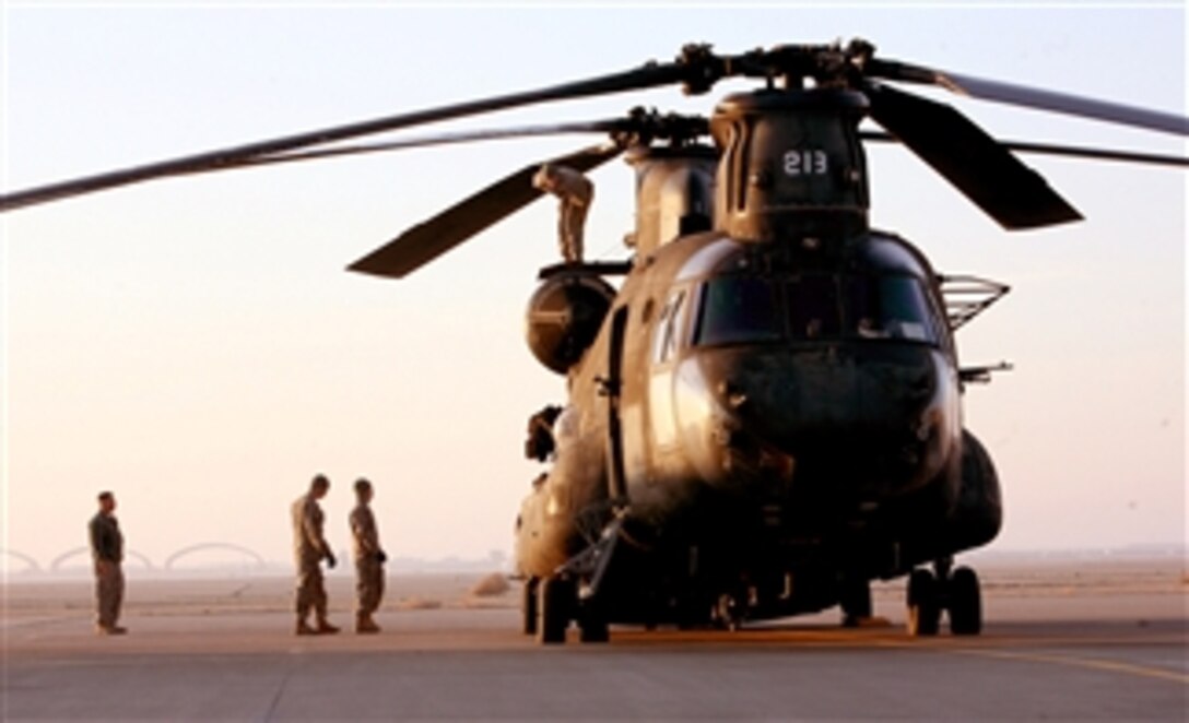 U.S. Army soldiers with Bravo Company, 1st Battalion, 214th Aviation Regiment, examine their CH-47 Chinook helicopter before an aircraft turnover mission at Al Asad Air Base, Iraq, on Dec. 1, 2009.  The aircraft are scheduled to be flown to Talil, Iraq, where Bravo Company, 5th Battalion, 159th Aviation Regiment will use them for support to Multi-National Division - South.   