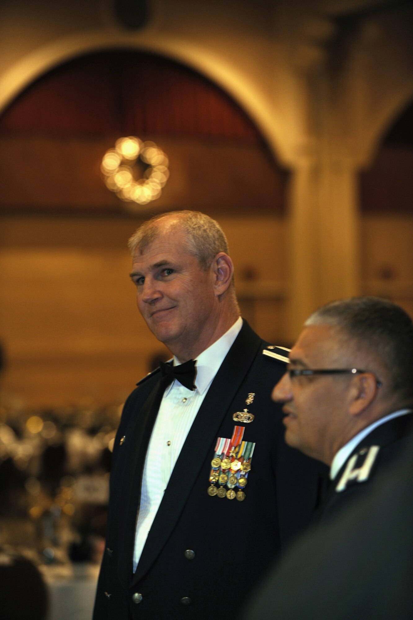 Guests stand during the singing of “The Star Spangled Banner,” the posting of the colors and the entry of distinguished parties. (U.S. Air Force photo by Master Sgt. Roy Santana)