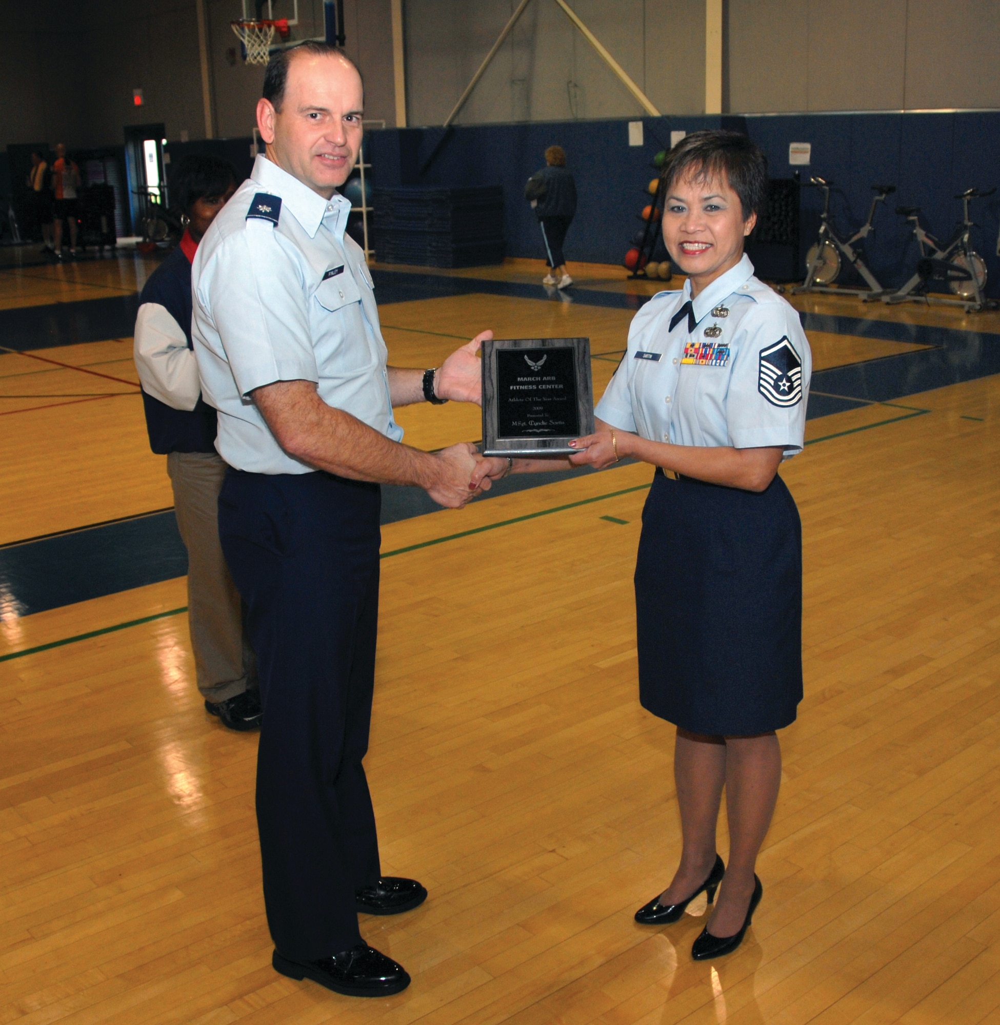 Lt. Col. Bruce Finley, 452nd Mission Support Group deputy commander, presents the Base Athlete of the Year award to Master Sgt. Cyndie Sartin, 163d Reconnaissance Wing, at the base gym, Dec. 7. (U.S. Air Force photo by Staff Sgt. Paul Duquette)
