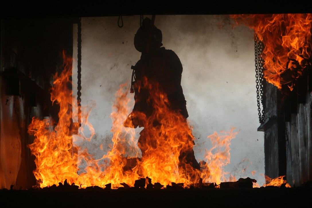 A fire academy instructor scrapes the remains of the fire in an effort to put it out. Verdugo Fire Academy, located in Los Angeles County, teamed up with the Miramar Fire Department for flashover training at East Miramar.