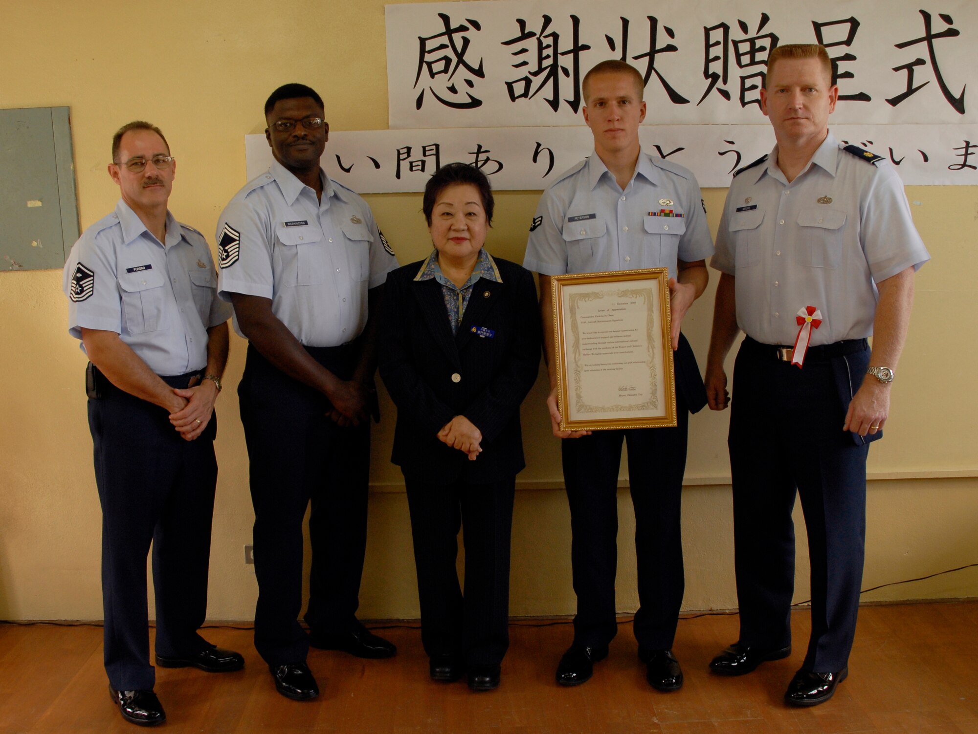 Kadena volunteers pose with Okinawa City Mayor Mitsuko Tomon (center) Dec. 11 at the Rainbow Heights Single Mothers Shelter in Okinawa City. The volunteers were recognized for their ongoing efforts with the shelter. (U.S. Air Force photo/Airman 1st Class Chad Warren)
