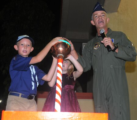 ANDERSEN AIR FORCE BASE, Guam - Col. Tod Fingal, 36th Wing vice commander, receives some assistance from two children during the Holiday Tree Lighting Ceremony here Dec. 3rd. The children wereselected to pull the switch that lit the tree for the first time during the holiday season. (U.S. Air Force photo by Airman 1st Class Julian North)