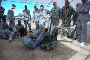 SOTO CANO AIR BASE, Honduras — Army Sgt. 1st Class Tohonn Nicholson, U.S. Army Combatives School instructor, demonstrates a stright arm bar from the guard postion Dec. 8 near the base soccer fields. Thirty five members of Joint Task Force-Bravo recently participated in an Army level-one combative certification course from Dec. 7 to 11 near the base soccer field. Students learned everything from basic fighting positions to submissions and clenches to sweeps and take downs in the five-day course. On the final day the students turned the table and taught the instructors what they had learned in the previous days (U.S. Air Force photo/Staff Sgt. Chad Thompson).