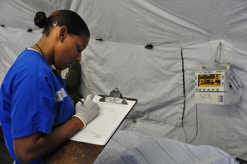 SOTO CANO AIR BASE, Honduras —  Air Force Staff Sgt. Kamesha Lewis, a member of the mobile surgical team, checks a patient's vital signs after a minor operation during an exercise here Dec. 10.  The team performed five minor surgeries removing "lumps and bumps" to add some realism to the exercise. The team itself is 100 percent mobile with a two-hour activation response time, and it can function alone for up to 72 hours. Their capabilities are to provide five major life- or limb-saving operations consecutively, and provide advanced trauma life support to 15 patients as well as providing limited post-operative recovery for surgical patients prior to evacuation (U.S. Air Force photo/Staff Sgt. Chad Thompson).