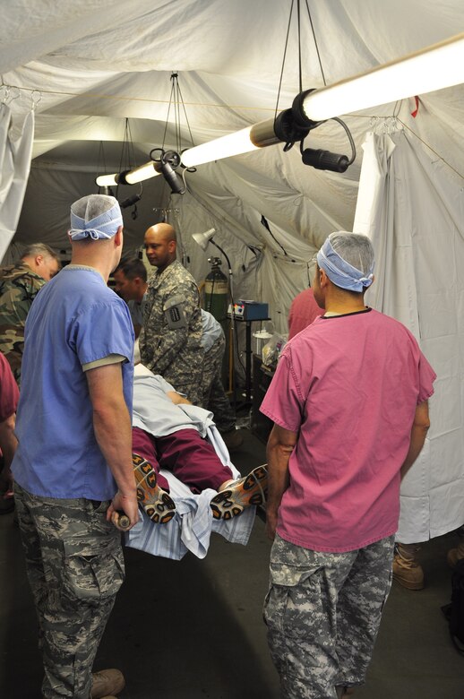 SOTO CANO AIR BASE, Honduras —  Members of the mobile surgical team move a patient into the operating room during an exercise here Dec. 10.  The team performed five minor surgeries removing "lumps and bumps" to add some realism to the exercise. The team itself is 100 percent mobile with a two-hour activation response time, and it can function alone for up to 72 hours. Their capabilities are to provide five major life- or limb-saving operations consecutively, and provide advanced trauma life support to 15 patients as well as providing limited post-operative recovery for surgical patients prior to evacuation (U.S. Air Force photo/Staff Sgt. Chad Thompson).