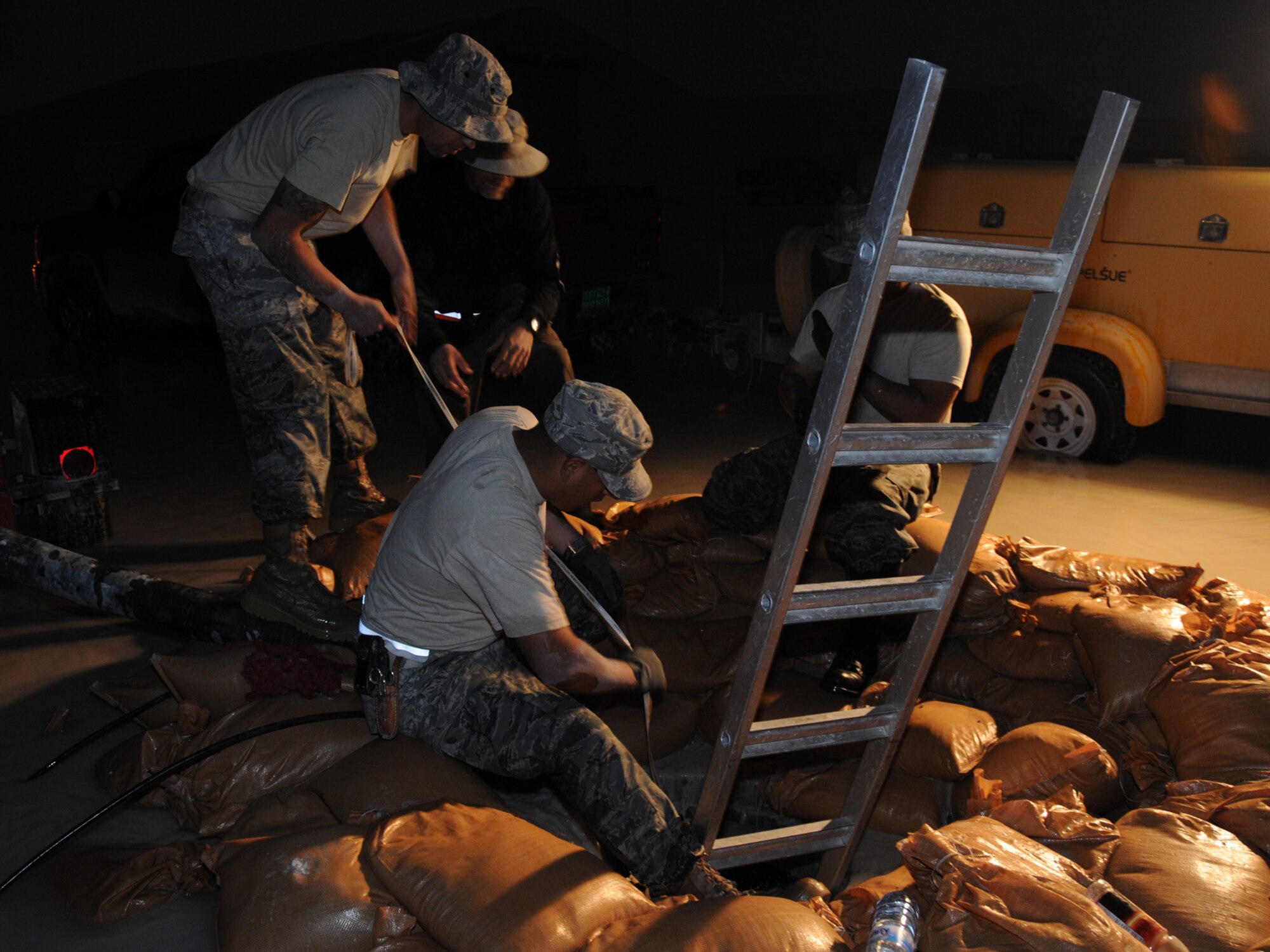 Members of the 379th Expeditionary Communications Squadron perform emergency repair on severed cables at a deployed location in Southwest Asia, Dec. 14, 2009. The base, which is located in an area that typically receives an average of 1.9 inches of rain annually, has received 1.06 inches in the last 24 hours.  (U.S. Air Force Photo/Tech. Sgt. Jason W. Edwards)