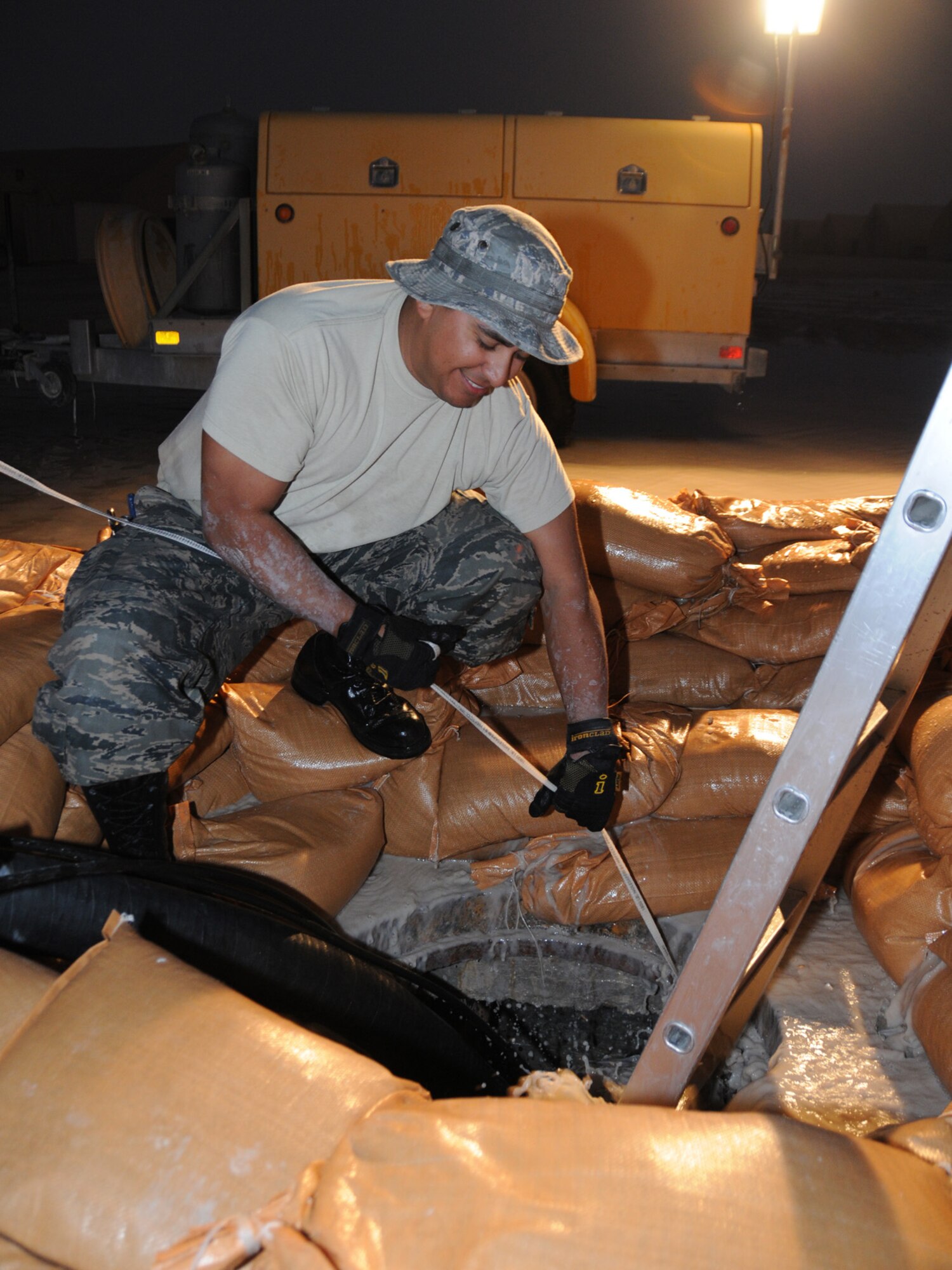 Staff Sergeant Kristofer Canales,379th Expeditionary Communications Squadron cable and antenna maintenance technician performs emergency repair on severed cables at a deployed location in Southwest Asia, Dec. 14, 2009. The base, which is located in an area that typically receives an average of 1.9 inches of rain annually, has received 1.06 inches in the last 24 hours.  (U.S. Air Force Photo/Tech. Sgt. Jason W. Edwards)