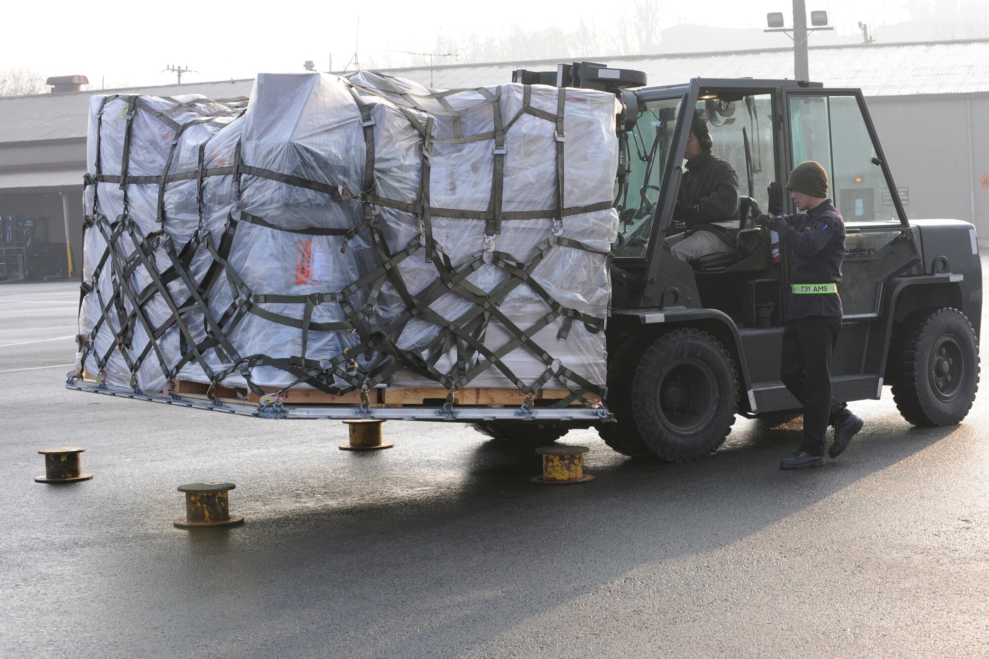 Korean Nationals from the 731st Air Mobility Squadron at Osan Air Base, Republic of Korea, direct cargo toward one of their storage facilities Dec. 12. More than 40 Korean personnel are part of the 731st AMS, ensuring the squadron is able to complete its mission as the center of mobility in the Republic of Korea. (U.S. Air Force Photo by 1st Lt. Chris Hoyler)