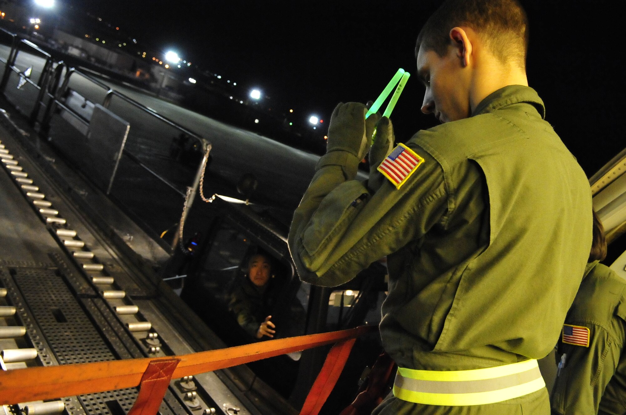 Airman 1st Class Jeff Suddy, 6th Air Refueling Squadron, directs a Korean National from the 731st Air Mobility Squadron prior to unloading cargo from a KC-10 Extender  Dec. 14. Korean National personnel with the 731st AMS contribute to the completion of much of the squadron's mission. (U.S. Air Force Photo by 1st Lt. Chris Hoyler) 