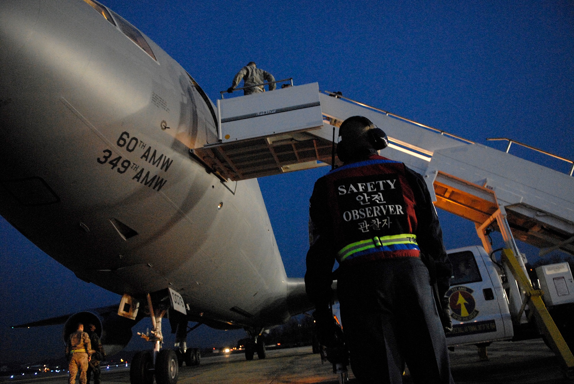 Senior Master Sgt. Jimmie Miller, 731st Air Mobility Squadron, looks on as Airmen from the 731st AMS prepare to unload passengers from a Travis Air Force Base, Calif. KC-10 Extender Dec. 14 at Osan Air Base, Republic of Korea. (U.S. Air Force Photo by Master Sgt. Marlin Zimmerman)