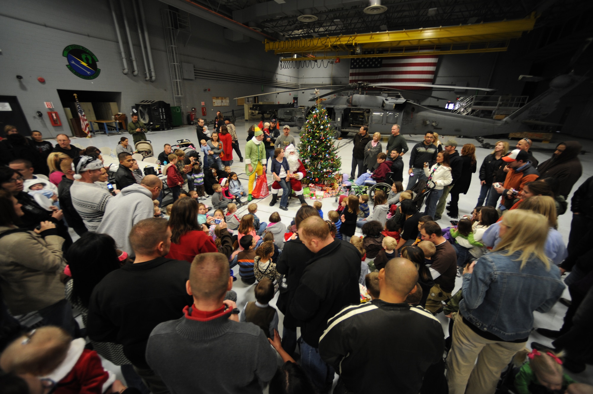 NELLIS AIR FORCE BASE, Nev.-- Santa Claus and his elf hand out gifts to children at the Nellis rescue community's annual children's Christmas party Dec. 12. The Nellis rescue community has been putting on the annual party for more than 10 years. 
(U.S. Air Force photo by Tech. Sgt. Michael R. Holzworth)