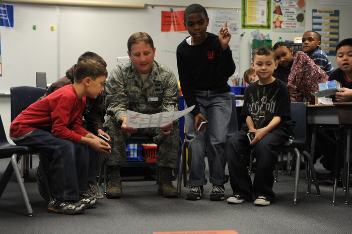 NELLIS AIR FORCE BASE, Nev.--  Col. Steven Winklmann, 99th Air Base Wing vice commander, and third grade students from Lomie Gray Heard Elementary School look over their community plans before beginning construction on their box city project Dec. 10. Colonel Winklmann spent the afternoon helping the children at the elementary school construct and place buildings throughout their make-believe community.  The architectural project helped the children understand the many different aspects that go into planning and creating a community.
(U.S. Air Force photo by Tech. Sgt. Michael R. Holzworth)