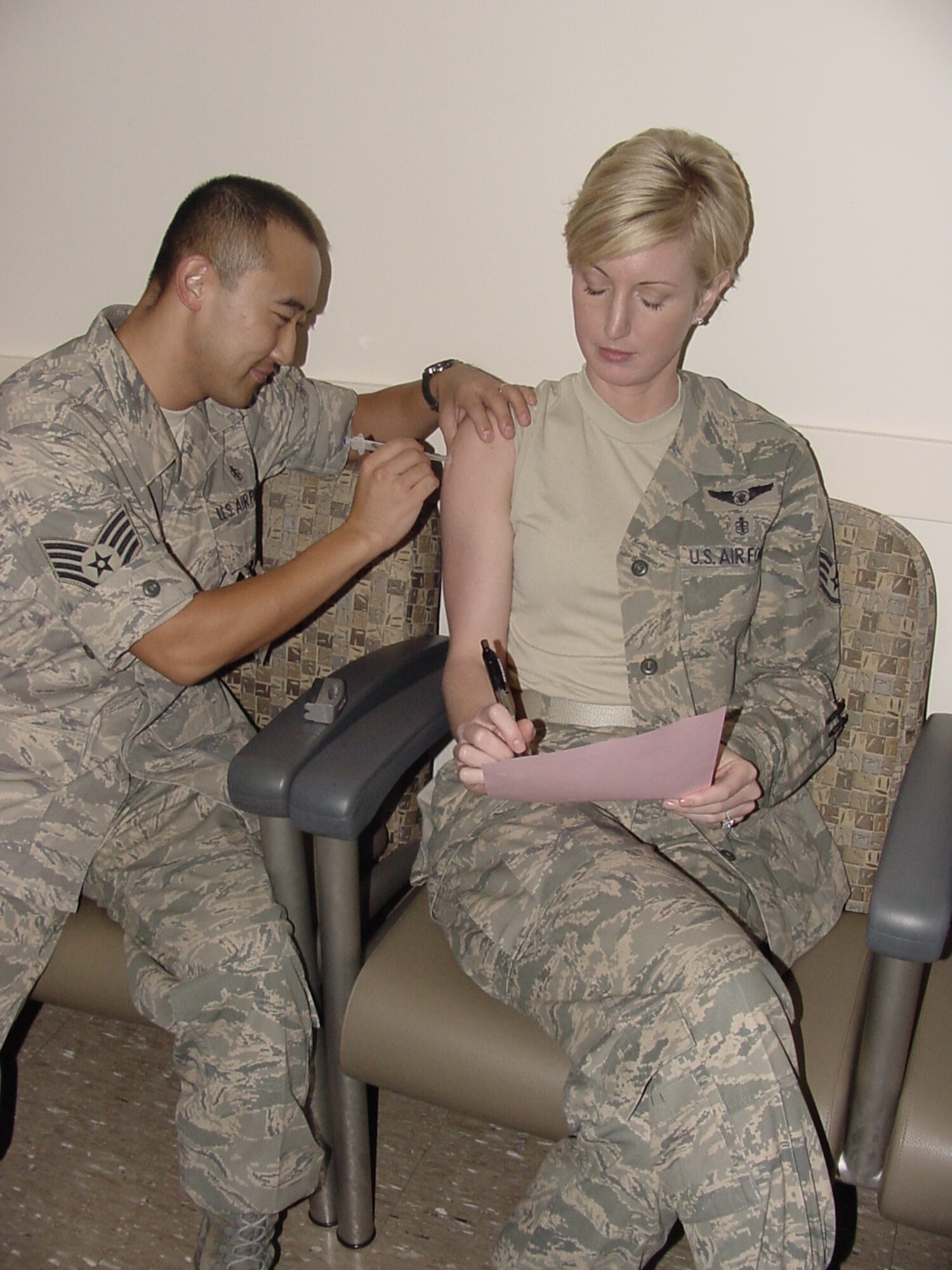 Staff Sgt. Kathleen Roe, 60th Medical Operations Squadron noncommissioned officer in charge of the Family Medicine Clinic’s Blue Element at David Grant USAF Medical Center, fills out an immunization questionnaire while receiving her H1N1 flu shot from Staff Sgt. Don Sim, 60 MDOS Family Medicine medical technician. The first shipments of H1N1 flu vaccine have arrived at DGMC with first priority being given to health-care providers and high-risk individuals ages 64 and under. Additional H1N1 vaccination clinics are scheduled throughout the remainder of the year for base personnel as additional shipments are delivered. (U.S. Air Force photo / Jim Spellman)