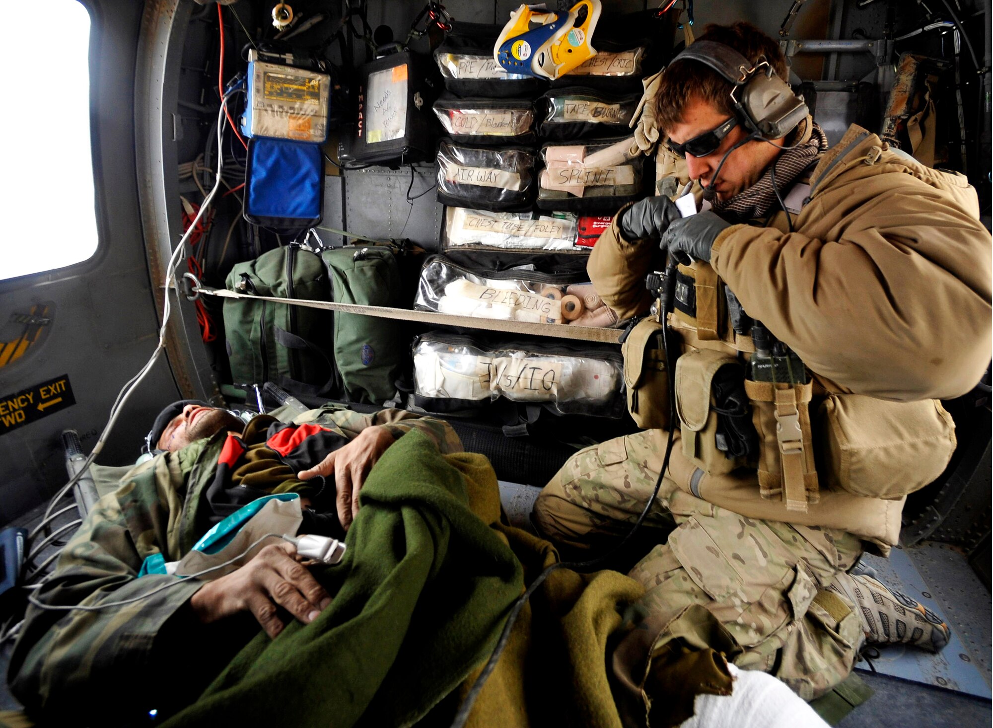 A U.S. Air Force Pararescueman from the 66th Expeditionary Rescue Squadron deployed to Camp Bastion, Afghanistan, provides medical attention to an Afghan who has suffered gunshot injuries, Dec. 8, 2009.  The PJs are able to rescue patients in any situation who need medical attention.  (U.S. Air Force photo/Staff Sgt. Angelita Lawrence)