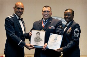 Col. Brian Robinson, left, and Chief Master Sgt. Tonia Savidge, right, present Senior Airman Alexander Jones with the John L. Levitow Award during the Airman Leadership School Class 10-A graduation the Charleston Club here Dec. 10. The award is given for a student's exemplary demonstration of excellence both as a leader and a scholar. Colonel Robinson is the 437th Airlift Wing vice commander, Chief Savidge is the 437th Medical Group superintendent and Airman Alexander is an air transportation specialist with the 437th Aerial Port Squadron. (U.S. Air Force photo/Airman 1st Class Lauren Laidlaw)