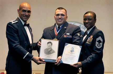 Col. Brian Robinson, left, and Chief Master Sgt. Tonia Savidge, right, present Senior Airman Alexander Jones with the John L. Levitow Award during the Airman Leadership School Class 10-A graduation the Charleston Club here Dec. 10. The award is given for a student's exemplary demonstration of excellence both as a leader and a scholar. Colonel Robinson is the 437th Airlift Wing vice commander, Chief Savidge is the 437th Medical Group superintendent and Airman Alexander is an air transportation specialist with the 437th Aerial Port Squadron. (U.S. Air Force photo/Airman 1st Class Lauren Laidlaw)