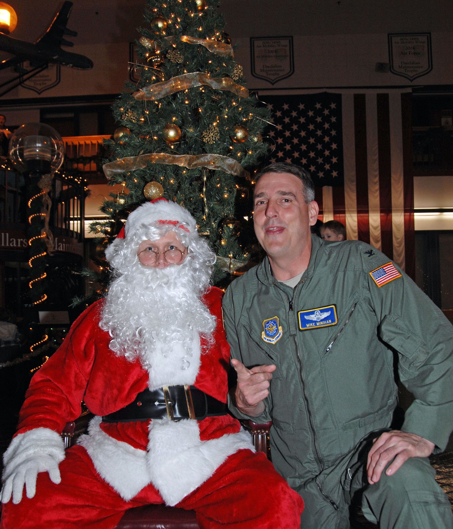 TRAVIS AIR FORCE BASE, Calif. -- Col. Mike Minihan, 60th Air Mobility Wing vice commander, tries to convince Santa that he's been very good this year. Col. Minihan visited the Team Travis Tree Festival and Auction to place his bids on the silent auction and chat with the Airmen and their families. Each year, the 60th Maintenance Operations Squadron and the 349th Maintenance Operations Flight host a Tree Festival and Auction to benefit the Travis Fisher House. Fisher Houses were the brainchild of Zachary and Elizabeth Fisher, who wanted to create a foundation to help military families in need, where they can stay, without charge, by the hospital where their military loved one is being treated. Located on the grounds of David Grant USAF Medical Center, the Travis Fisher House is one of more than 30 built by this foundation. This year's festival raised about $2,700.  (U.S. Air Force/photo SMSgt. Ellen L. Hatfield) (U.S. Air Force/photo Senior Master Sgt. Ellen L. Hatfield)