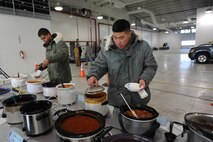 MINOT AIR FORCE BASE, N.D. -- Airman 1st Class Terence Bow and Airman David Lee, both 5th Comptroller Squadron accounting technicians, decide which chili they would like to try during the First Sergeant’s Chili Feed here Dec. 10. The First Sergeant’s Chili Feed featured over 20 different types of chili and was open to Airmen, E-1 to E-4. (U.S. Air Force photo by Senior Airman Sharida Jackson)