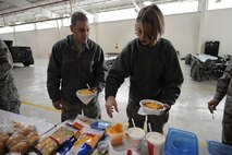MINOT AIR FORCE BASE, N.D. -- Senior Airmen Patrick Preston and Heather Williamson, both 5th Maintenance Squadron aerospace propulsion craftsmen, place toppings on chili during the First Sergeant’s Chili Feed here Dec. 10. The First Sergeant’s Chili Feed featured over 20 different types of chili and was open to Airmen, E-1 to E-4. (U.S. Air Force photo by Senior Airman Sharida Jackson)