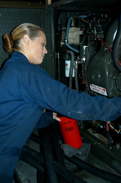OFFUTT AIR FORCE BASE, Neb. -- Senior Airman Theresa E. Civil, an aerospace ground equipment mechanic with the 55th Maintenance Squadron, checks the oil in a diesel engine driven generator inside the Bennie Davis Maintenance Facility here Dec. 14. The generator is one of many that provide Offutt's aircraft with power while their on the flightline. Airman Civil balances many responsibilities to ensure she is mission ready including taking care of her mother, while being a mom herself. U.S. Air Force Photo by Staff Sgt. James M. Hodgman          