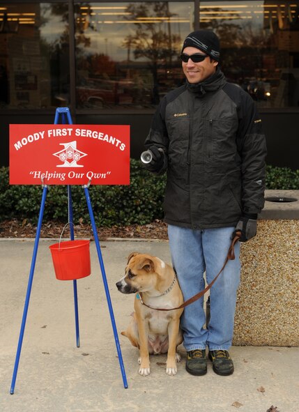MOODY AIR FORCE BASE, Ga. -- Master Sgt. Roger Martinez, 723rd Aircraft Maintenance Squadron electronic warfare supervisor, along with his dog, Buddy, volunteer to help collect donations during the Ring-a-Bell program here Dec. 11. Sergeant Martinez is helping to raise money for the Moody First Sergeants' Association to assist Moody families in need during the holiday season. (U.S. Air Force photo by Airman 1st Class Benjamin Wiseman)