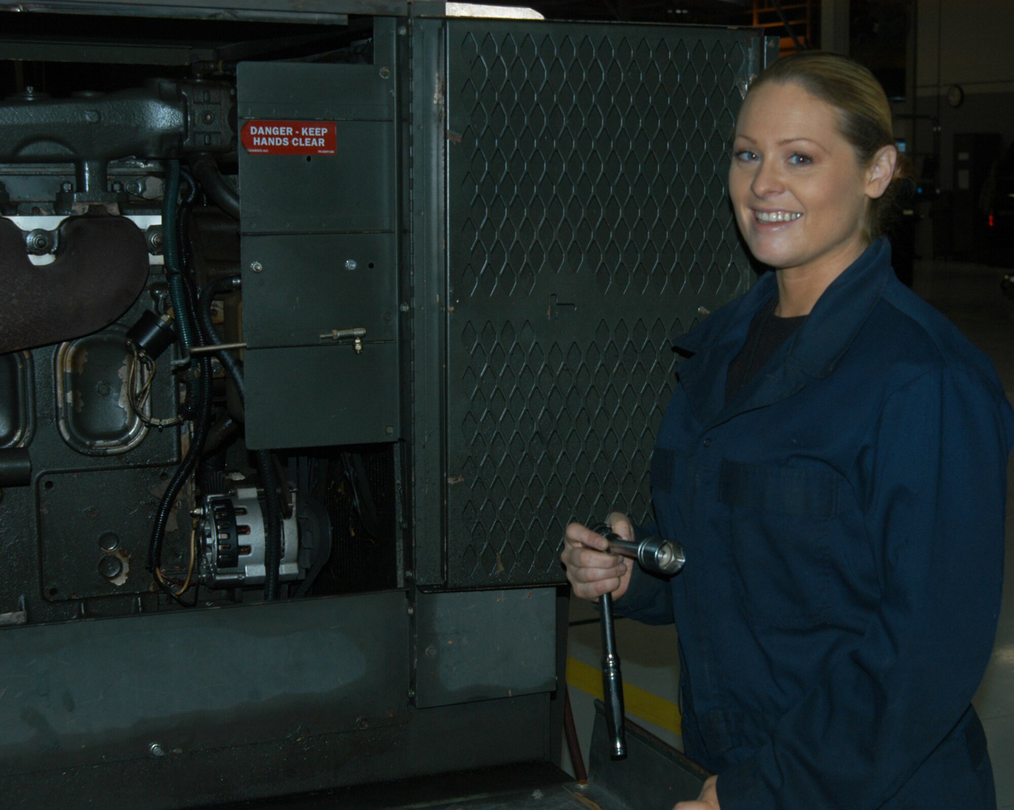 OFFUTT AIR FORCE BASE, Neb. -- Senior Airman Theresa E. Civil, an aerospace ground equipment mechanic with the 55th Maintenance Squadron, poses for a photo in front of a diesel engine driven generator inside the Bennie Davis Maintenance Facility here Dec. 14. The generator is one of many that provide Offutt's aircraft with power while their on the flightline. Airman Civil balances many responsibilities to ensure she is mission ready including taking care of her mother, while being a mom herself. U.S. Air Force Photo by Staff Sgt. James M. Hodgman 