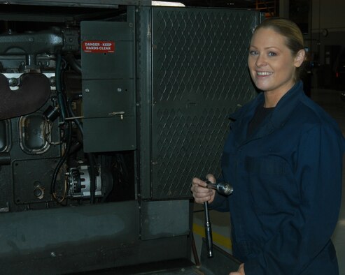 OFFUTT AIR FORCE BASE, Neb. -- Senior Airman Theresa E. Civil, an aerospace ground equipment mechanic with the 55th Maintenance Squadron, poses for a photo in front of a diesel engine driven generator inside the Bennie Davis Maintenance Facility here Dec. 14. The generator is one of many that provide Offutt's aircraft with power while their on the flightline. Airman Civil balances many responsibilities to ensure she is mission ready including taking care of her mother, while being a mom herself. U.S. Air Force Photo by Staff Sgt. James M. Hodgman 