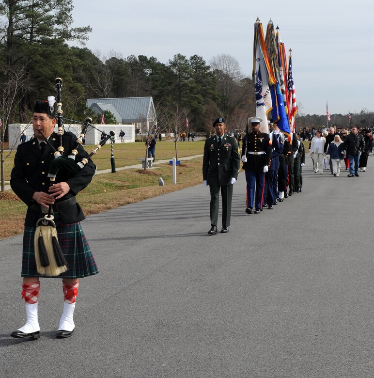 SUFFOLK, Va. -- Bagpiper David Lotz leads a joint forces honor guard toward the last row of resting places to be presented wreaths, during the Wreaths Across America ceremony Dec. 12.  Military personnel and the local community laid 2,250 wreaths on the headstones of fallen veterans.  (U.S. Air Force photo/Senior Airman Zachary Wolf)

