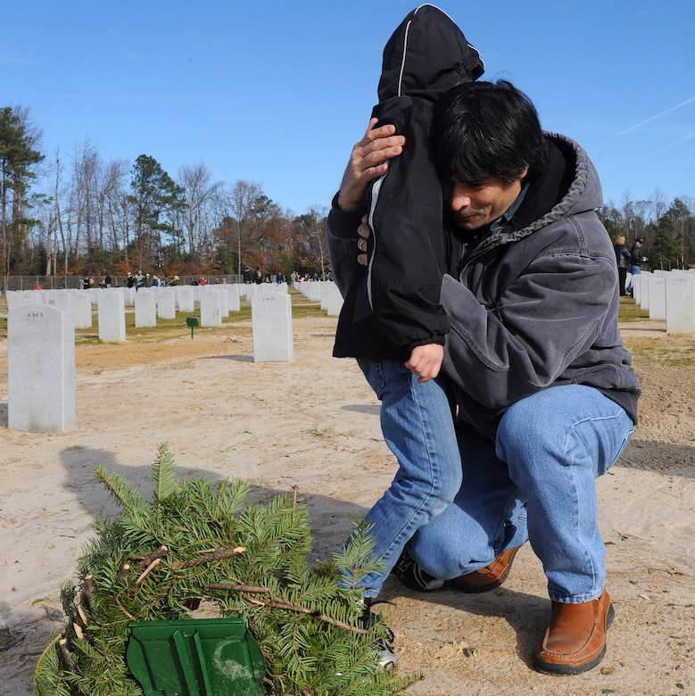 SUFFOLK, Va. -- Tai Swindell hugs his son, Dakota Swindell, after paying respects to James M. Swindells, Tai's father and World War II veteran, during the Wreaths Across America program Dec. 12.  Military personnel and the local community laid 2,250 wreaths on the headstones of fallen veterans.  (U.S. Air Force photo/Senior Airman Zachary Wolf)

