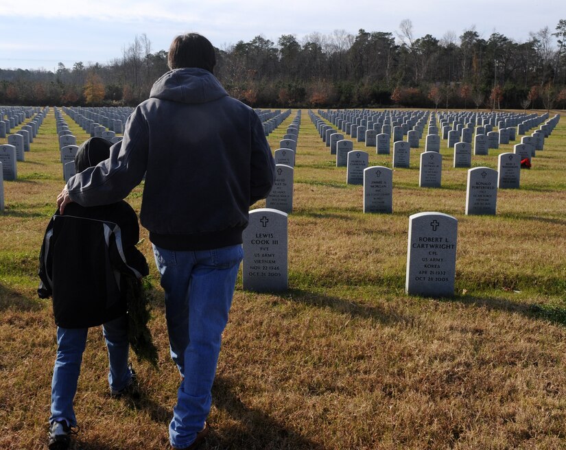 SUFFOLK, Va. -- Tai Swindells and his son, Dakota Swindells, visit the resting place of James M. Swindells, Tai's father and World War II veteran, during the Wreaths Across America program Dec. 12. Military personnel and the local community laid 2,250 wreaths on the headstones of fallen veterans.  (U.S. Air Force photo/Senior Airman Zachary Wolf) 