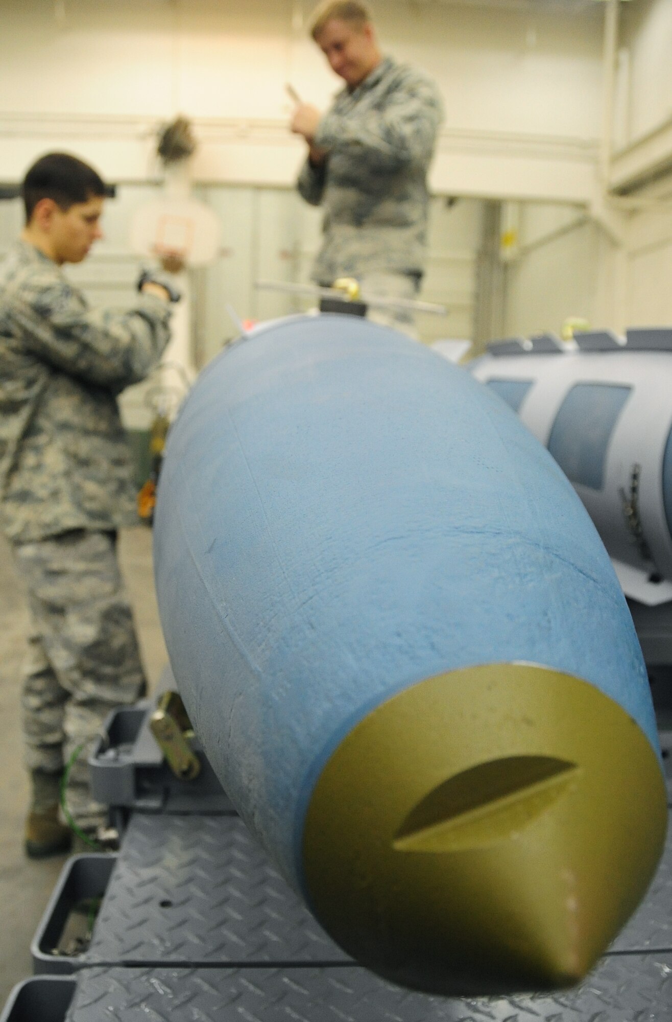 ELLSWORTH AIR FORCE BASE, S.D. -- (Left to right) Airman 1st Class Aaron Valdez and Senior Airman Myco Wilson, 28th Munitions Squadron conventional maintenance crew members, take apart their tools after securing an aerosurface assembly on an inert Guided Bomb Unit-31, Dec. 8.  The aerosurface assembly is designed to stabilize the GBU-31. (U.S. Air Force photo/Airman 1st Class Anthony Sanchelli)






