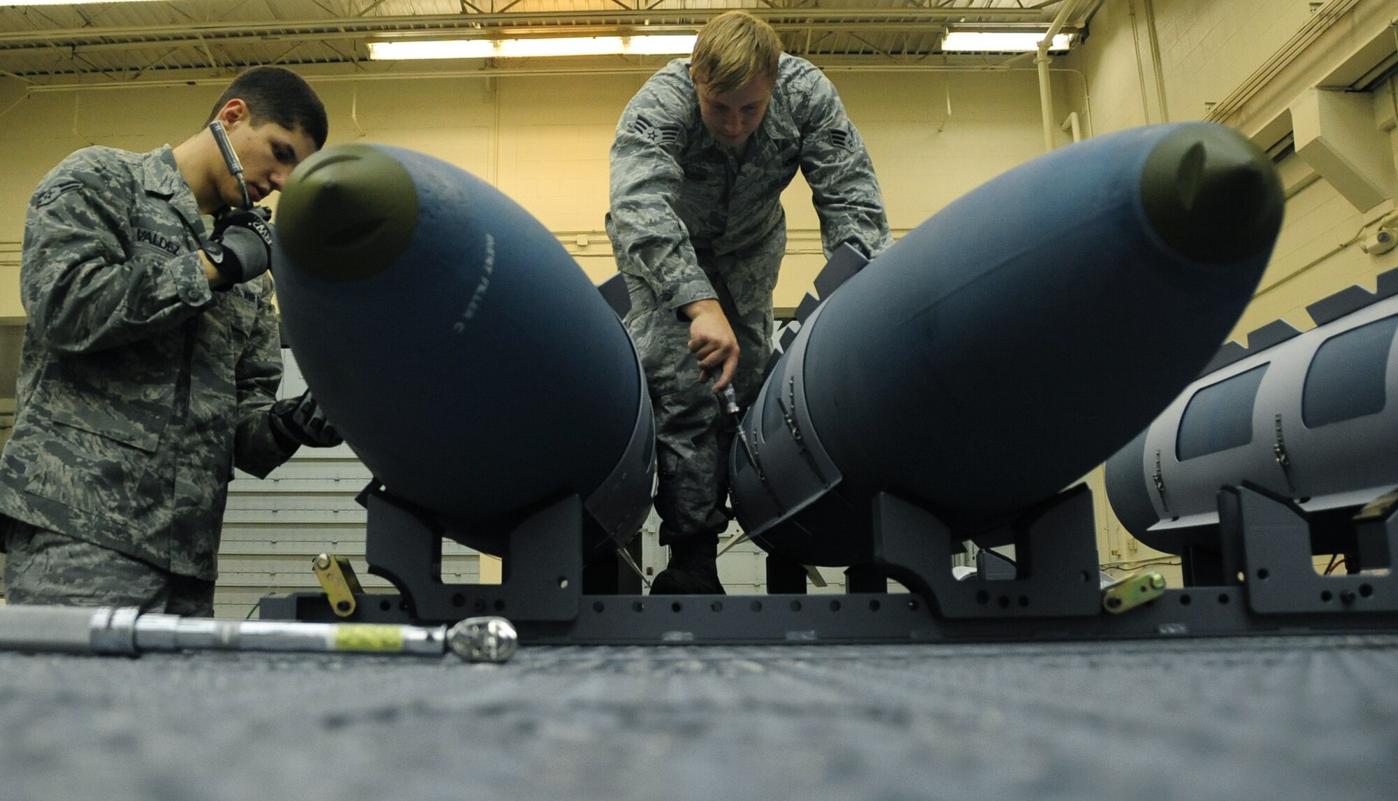 ELLSWORTH AIR FORCE BASE, S.D. -- (Left to right) Airman 1st Class Aaron Valdez and Senior Airman Myco Wilson, 28th Munitions Squadron conventional maintenance crew members, secure an aerosurface assembly on an inert Guided Bomb Unit-31, Dec. 8.  The aerosurface assembly is designed to stabilize the GBU-31. (U.S. Air Force photo/Airman 1st Class Anthony Sanchelli)




