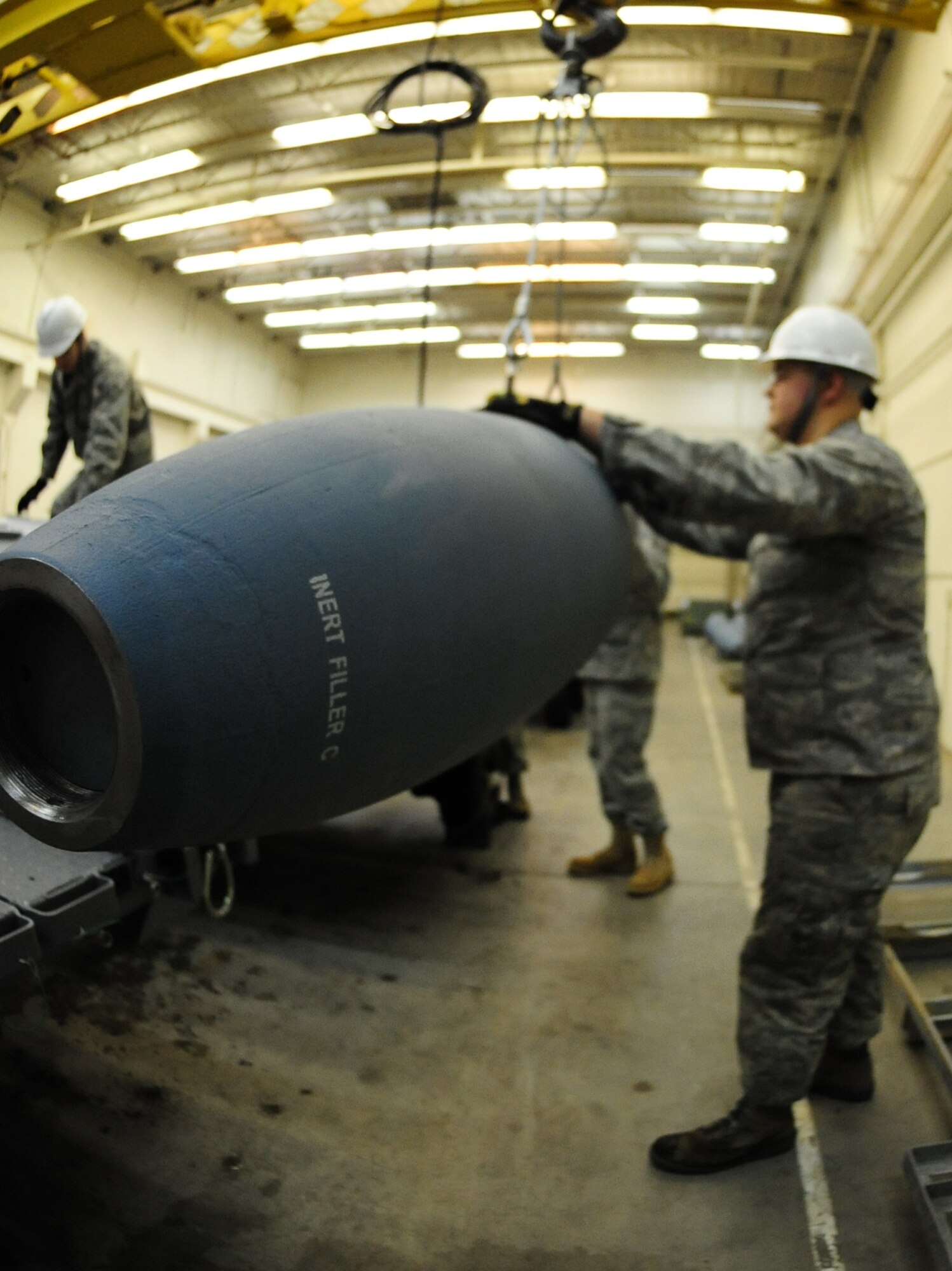 ELLSWORTH AIR FORCE BASE, S.D. -- Airman 1st Class Michael DiRienzo, 28th munitions Squadron conventional maintenance crew member, hold an inert Guided Bomb unit-31 as it is hoisted onto a bomb trailer, Dec. 8.  Airman DiRienzo, along with others, put together several inert GBU-31 bombs for training missions on the B-1B Lancer. (U.S. Air Force photo/Airman 1st Class Anthony Sanchelli)
