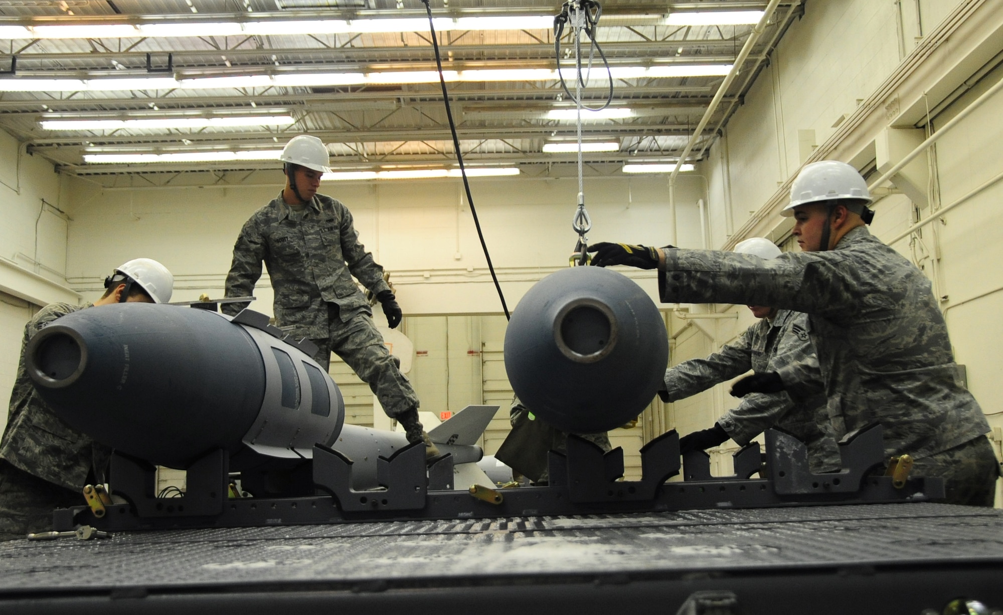 ELLSWORTH AIR FORCE BASE, S.D. -- (Left to right) Airmen 1st Class Aaron Valdez, Derrick Scott, Senior Airman Myco Wilson and Airman 1st Class Michael DiRienzo, 28th munitions Squadron conventional maintenance crew members, put together several inert Guided Bomb unit-31, Dec. 8.  Inert GBU-31 bombs are designed for training missions with the B-1B Lancer. (U.S. Air Force photo/Airman 1s Class Anthony Sanchelli)