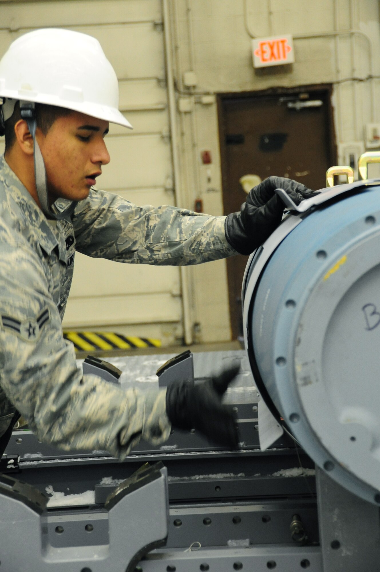 ELLSWORTH AIR FORCE BASE, S.D. -- Airman 1st Class Franklin Saa, 28th Munitions Squadron conventional maintenance crew member, attaches an aerosurface assembly on an inert Guided Bomb Unit-31, Dec. 8.  The aerosurface assembly is designed to stabilize the GBU-31. (U.S. Air Force photo/Airman 1st Class Anthony Sanchelli)