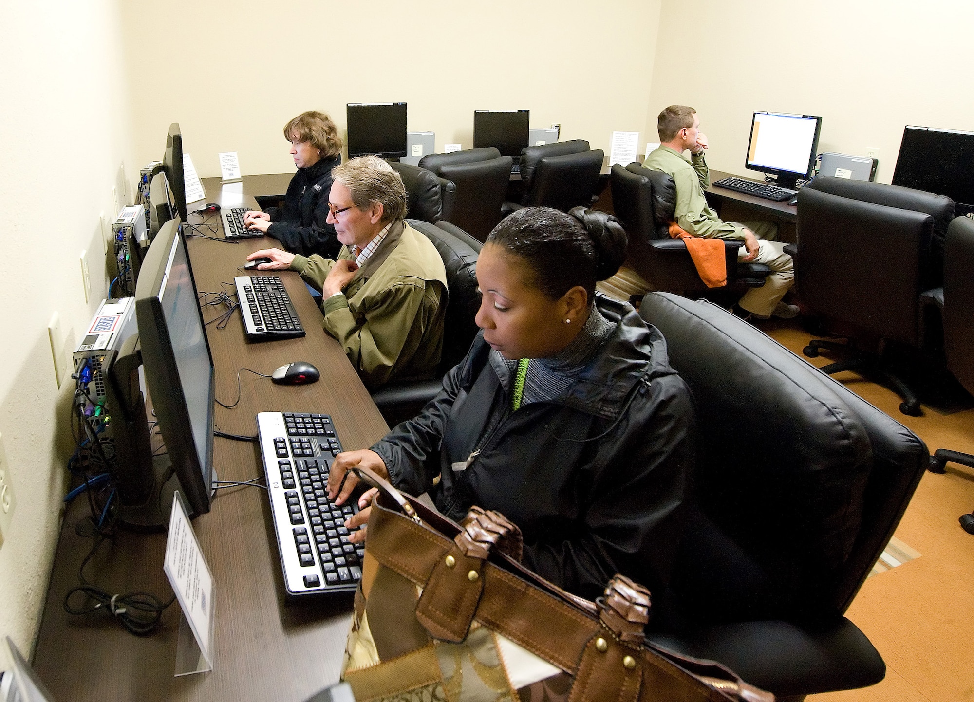 Passengers waiting for space available flights use computers at the new USO Lounge in the Dover Air Force Base Passenger Terminal. The lounge has a snack area that offers free food and beverages to patrons. (U.S. Air Force photo/Jason Minto)