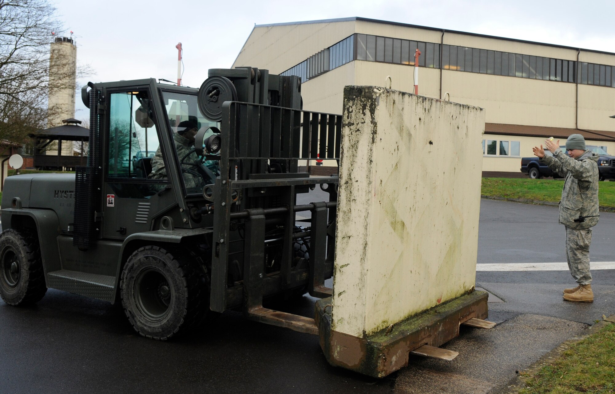 SPANGDAHLEM AIR BASE, Germany – Staff Sgt. Craig Bundy spots Airman 1st Class Jeffery Brown as he transports a barrier during an Installation Barrier Plan exercise Dec. 9. The Airmen, both from the 52nd Logistics Readiness Squadron, participated in the exercise, which tested the base’s readiness in the event of a real-world Force Protection Condition increase. (U.S. Air Force photo/Airman 1st Class Staci Miller)