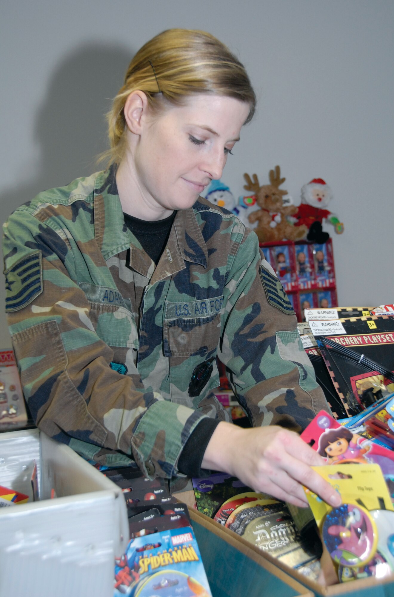 Tech. Sgt. Nicole Adams organizes toys for Operation Helping Hand during the December unit training assembly. Sergeant Adams assisted the 442nd Airman and Family Readiness office distribute gifts to hundreds of servicemembers. The 442nd Fighter Wing is an Air Force Reserve unit at Whiteman Air Force Base, Mo. (U.S. Air Force Photo/Senior Airman Danielle Wolf)