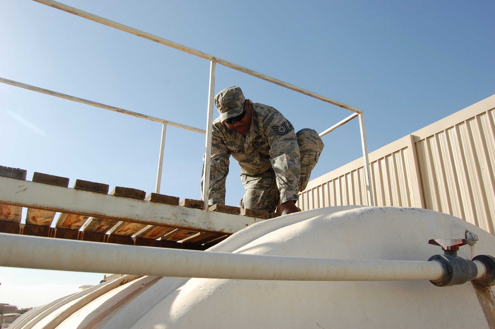 SOUTHWEST ASIA -- Tech. Sgt. Anthony Collins, 64th Expeditionary Support Squadron civil engineer, checks the water measurement in a tank at the Desert Winds Dining Facility at an undisclosed location in Southwest Asia, Dec. 9. Sergeant Collins is deployed from Andrews Air Force Base, Md., in support of operations Iraqi Freedom and Enduring Freedom. (U.S. Air Force Photo/Staff Sgt. Kyle Ray)