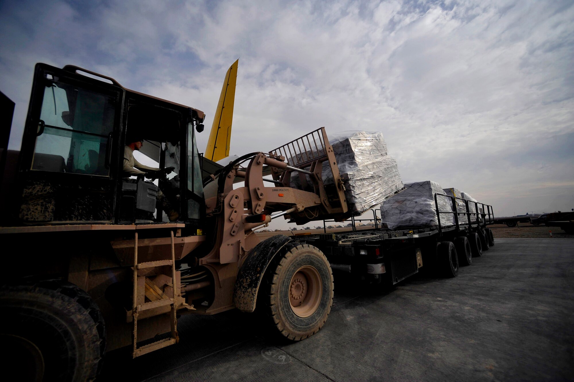 U.S. Air Force Airman 1st Class Joshua McGee, 451st Expeditionary Logistics Readiness Squadron Det. 1 air transportation apprentice stationed at Pope AFB, N.C., deployed to Camp Bastion, Afghanistan, places pallets onto a 60K loader, Dec. 11, 2009. The 451st ELRS received 18 pallets for the members of Camp Bastion.  (U.S. Air Force photo/Staff Sgt. Angelita Lawrence)
