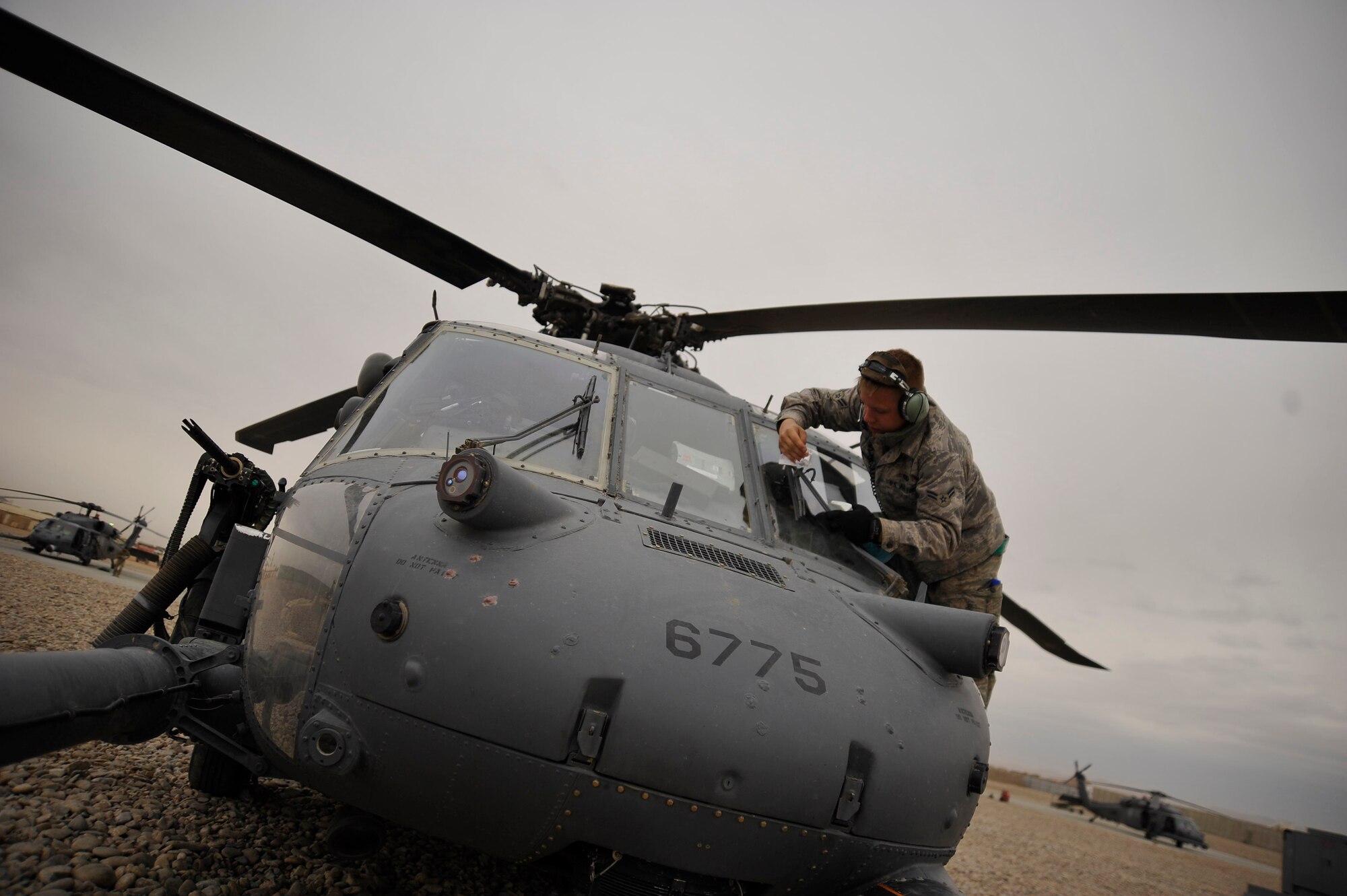 U.S. Air Force Airman 1st Class William Chennault, 451st Air Expeditionary Squadron crew chief, stationed at Moody AFB, Ga., deployed to Camp Bastion, Afghanistan, wipes the windshield of an HH-60 Pave Hawk, Dec. 8, 2009. Wiping down the windows during the pre-loading phase ensures the pilots have 100 percent visibility during their rescue mission. (U.S. Air Force photo/Staff Sgt. Angelita Lawrence)
