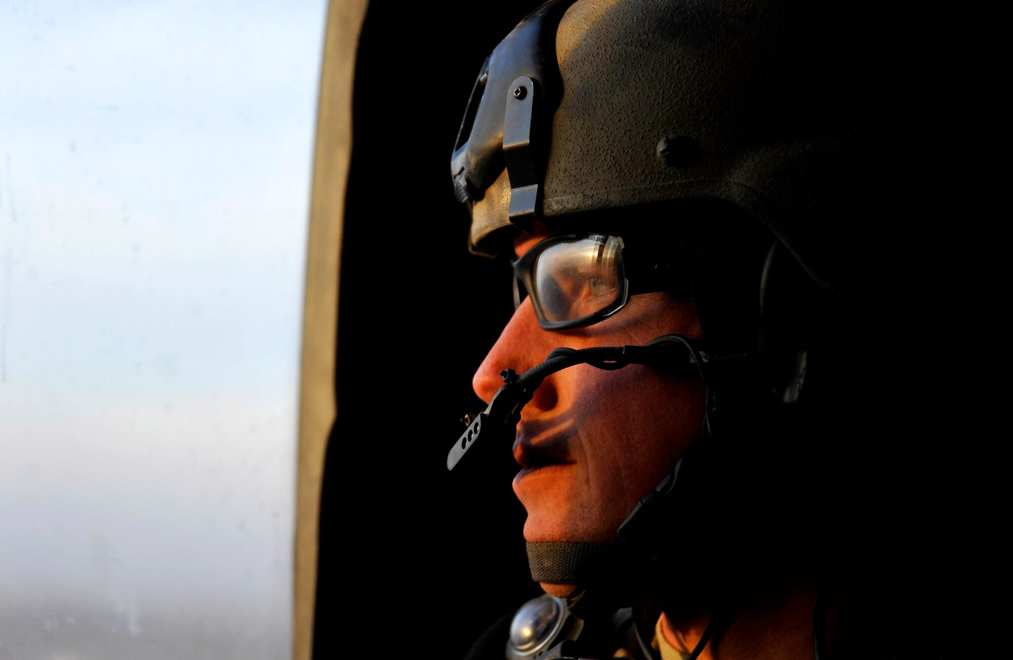 A U.S. Air Force Combat Rescue Officer from the 66th Expeditionary Rescue Squadron stationed at Davis-Monthan AFB, Ariz., deployed to Camp Bastion, Afghanistan, looks out the door of an HH-60 Pave Hawk, Dec. 7, 2009. The members of the 66th ERQS can respond to a medical evacuation in less than seven minutes to pick up patients in need of care.  (U.S. Air Force photo/Staff Sgt. Angelita Lawrence)
