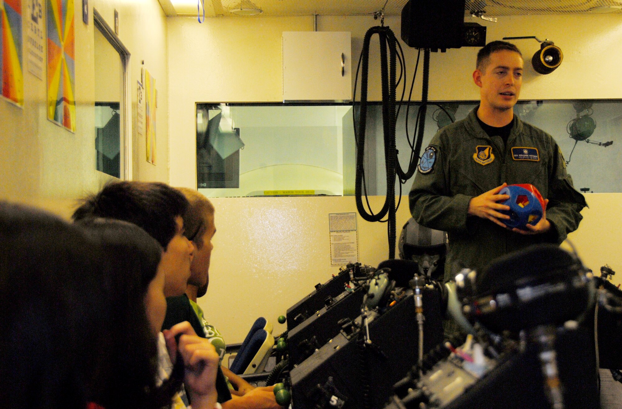 Senior Airman Benjamin Hoffman, 18th Medicine Squadron Physiological Training Flight, briefs students on the use of the hyperbaric chamber during a “Physics in Flight” fieldtrip Dec. 11. The students learned how physics relates to aviation and witnessed how those theories are applied at Kadena. Students received briefings and tours of the 67th Fighter Squadron including the flight line, 18th Aerospace Medical Squadron Physiological Training Flight and 18th Operations Support Squadron Radar Approach Control. (U.S. Air Force photo/Staff Sgt. Kenya Shiloh)