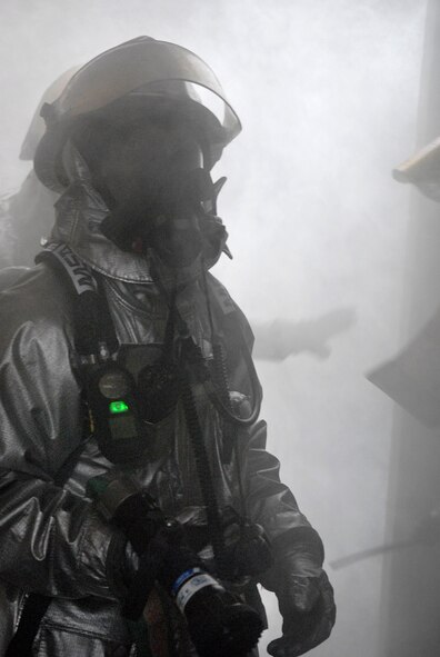 Firefighters from the 51st Civil Engineering Squadron drag a fire hoze into a smoke-filled building during an emergency management exercise here Dec. 10 at Osan Air Base, Republic of Korea. The exercise tested Osan's emergency response to situations and provided valuable training opportunities for the 51st Fighter Wing emergency response agencies. (U.S. Air Force photo/Master Sgt. Marlin Zimmerman)