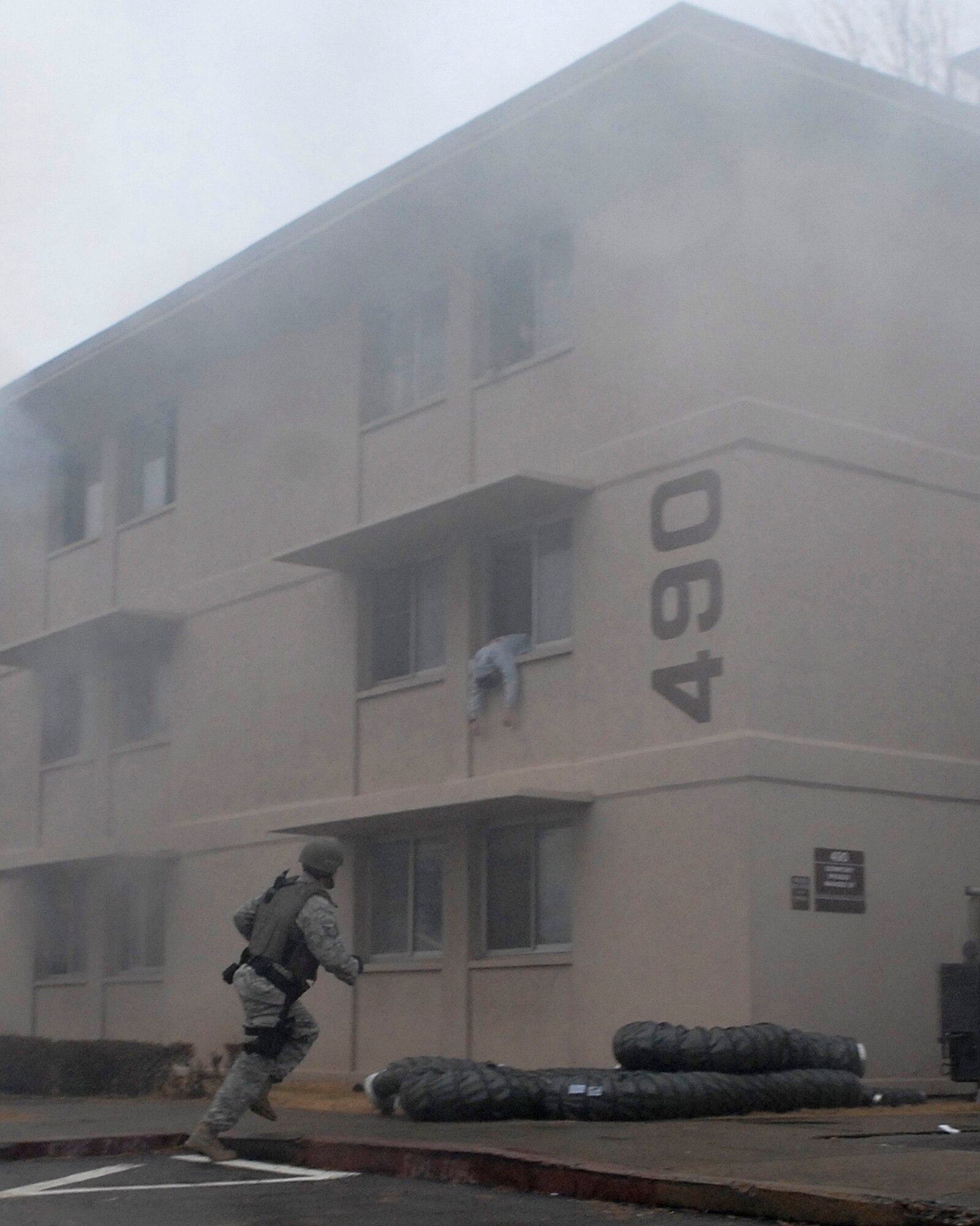 An Airman from the 51st Security Forces Squadron rushes into a simulated burning building during an emergency management exercise here Dec. 10 at Osan Air Base, Republic of Korea. The exercise tested Osan's emergency response to situations and provided valuable training opportunities for the 51st Fighter Wing emergency response agencies. (U.S. Air Force photo/Master Sgt. Marlin Zimmerman)